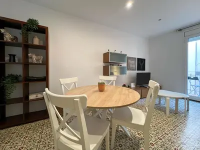 a dining room with a wooden table and white chairs at Stay U-nique Apartments Begur in Barcelona