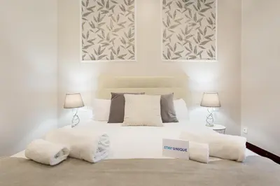 a bedroom with a large white bed with two lamps at Stay U-nique Apartments Calvet in Barcelona
