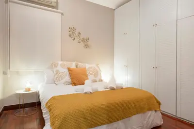 a bedroom with a bed with a yellow blanket at Stay U-nique Apartments Calvet in Barcelona