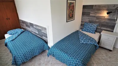 two beds with blue pillows in a bedroom at MARILU SEAVIEW & BEACH - apartment in Masnou