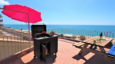 a grill on a balcony with a red umbrella at MARILU SEAVIEW & BEACH - apartment in Masnou