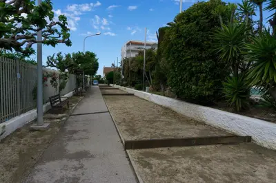 a sidewalk with benches and trees on a street at Precioso apartamento en la playa Barcelona in Cabrera de Mar