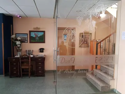 a glass door in a room with a desk and stairs at Hotel Don Pelayo in Arbós