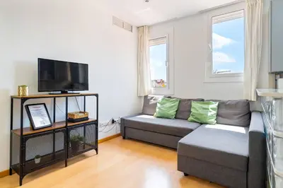 a living room with a couch and a flat screen tv at Rooftop Terrace BBQ in Gràcia AC in Barcelona