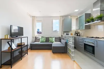 a living room with a couch and a kitchen at Rooftop Terrace BBQ in Gràcia AC in Barcelona