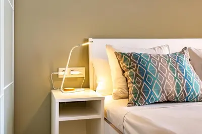 a bed with a lamp on a night stand next to a bed at Three bedrooms apartment in Barcelona