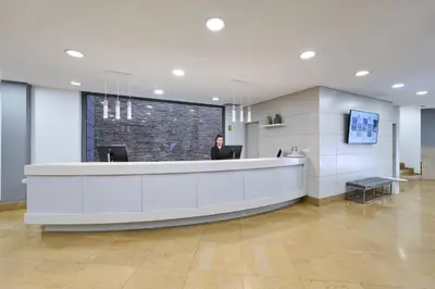 a woman standing at a reception desk in a lobby at Catalonia La Boquería in Barcelona