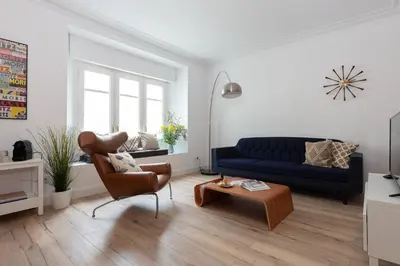 a living room with a blue couch and a chair at Casa Cosi - Eixample 2 in Barcelona