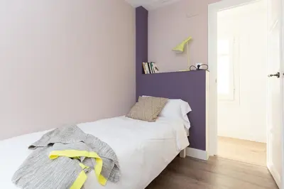 a bedroom with a white bed and a purple wall at Casa Cosi - Eixample 2 in Barcelona