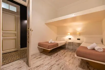 a small room with two beds and a bathroom at eg21- MODERNIST AND ELEGANT APARTMENT IN BCN CITY CENTER in Barcelona