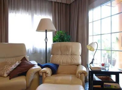 a living room with a chair and a lamp at Villa Magnolia in Mataró