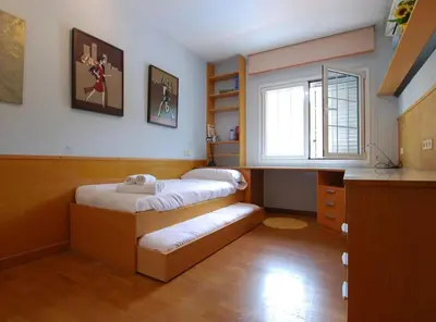 a small room with two beds and a window at Villa Magnolia in Mataró