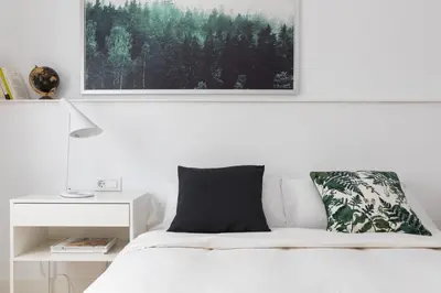 a bedroom with a white bed with a picture above it at Casa Cosi - Eixample 3 in Barcelona
