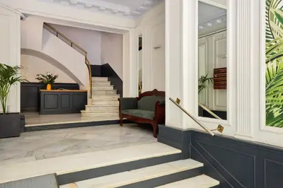 a living room with stairs and a chair at Casa Cosi - Eixample 3 in Barcelona