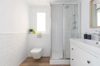 a white bathroom with a toilet and a shower at Casa Cosi - Eixample 3 in Barcelona