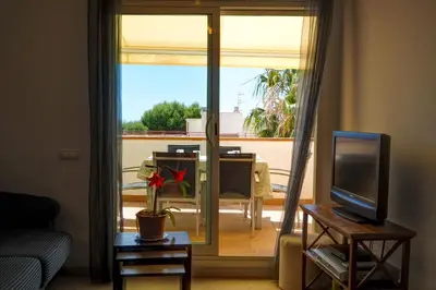 a living room with a sliding glass door to a balcony at Portman Duplex by Hello Homes Sitges in Sitges