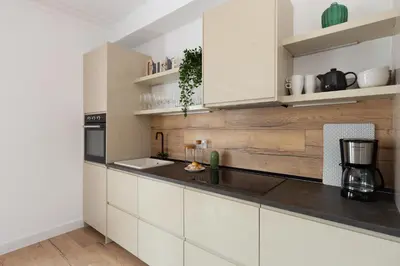 a kitchen with white cabinets and black counter tops at Casa Cosi - Eixample 4 in Barcelona