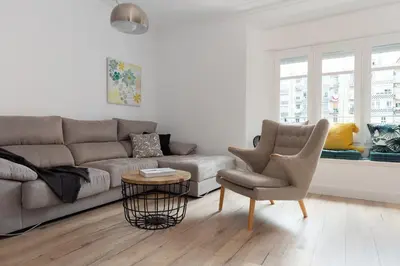 a living room with a couch and a chair at Casa Cosi - Eixample 4 in Barcelona