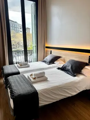 a living room with a gray couch and a mirror at Hostalin Barcelona Gran Via in Barcelona