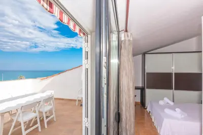 a room with a bed and a view of the ocean at HomeHolidaysRentals Escapade in Pineda de Mar