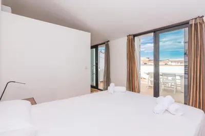 a bedroom with a bed and a large window at HomeHolidaysRentals Escapade in Pineda de Mar