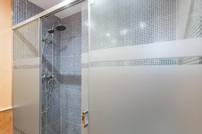 a shower with a glass door in a bathroom at HomeHolidaysRentals Escapade in Pineda de Mar