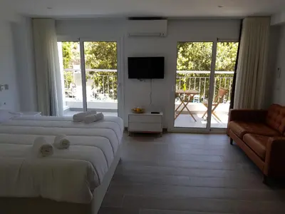 a bedroom with two beds and a television and a couch at Krm Suite Apartament in Calella