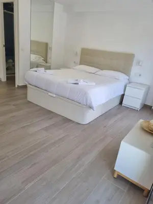 a bedroom with a large bed and a mirror at Krm Suite Apartament in Calella