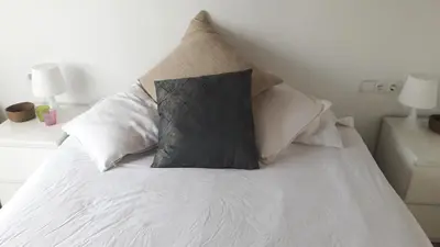 a bed with white sheets and pillows on it at BlauMasnou One step to the beach! in Masnou