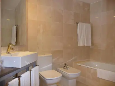 a bathroom with a sink and a toilet and a tub at Hotel Verti in Corró de Vall