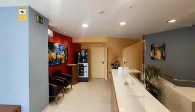 a waiting room with red walls and a long hallway at Hotel Verti in Corró de Vall
