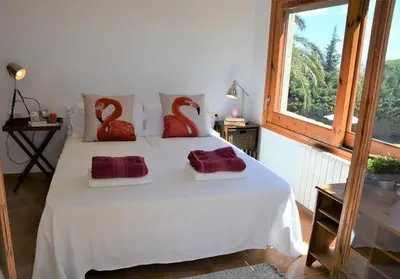 a bedroom with a bed with two red swans pillows at Villa Sitges Colibri at 10 min Walk Beaches - Center City Amaizing Garden Pool XXL Private Tenis Piste in Vilanova i la Geltrú