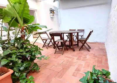 a patio with a table and chairs and plants at Clot MiraBarna Apartments in Barcelona