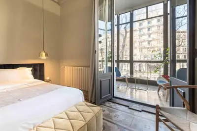 a bedroom with a bed and a large window at BUHO Boutique Rooms in Barcelona