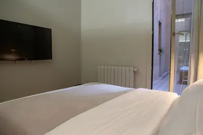 a bedroom with a bed and a table with a book at BUHO Boutique Rooms in Barcelona