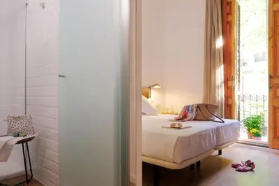 a bedroom with a bed and a window at Som Nit Triomf in Barcelona