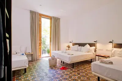 a hotel room with two beds and a couch at Som Nit Triomf in Barcelona