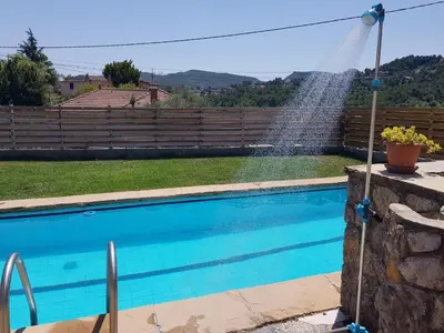 a pool with a sprinkler spraying water over it at Apartament Vall de Montserrat in Castellbell i Vilar