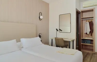 a bedroom with a bed and a desk and a mirror at Hostal Centric in Barcelona