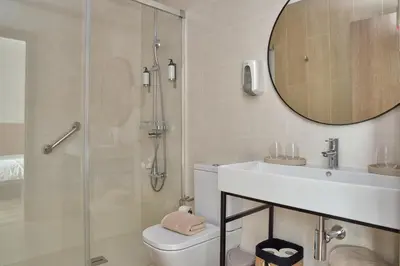 a bathroom with a shower and a toilet and a sink at Hostal Centric in Barcelona