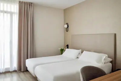 a hotel room with two beds and a window at Hostal Centric in Barcelona
