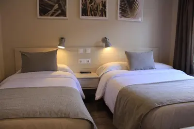 a bedroom with a bed and a table with a lamp at Hostal La Romànica in Sabadell