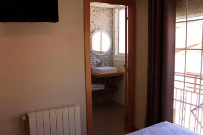 a hospital room with a door and a mirror at Hostal La Romànica in Sabadell