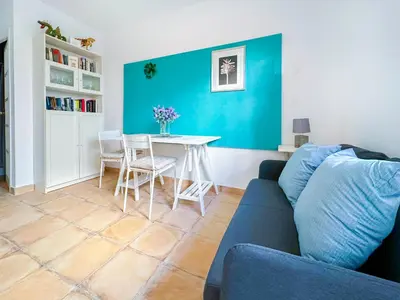 a patio with a wooden table and an umbrella at Gladiator Apartment by Hello Homes Sitges in Sitges