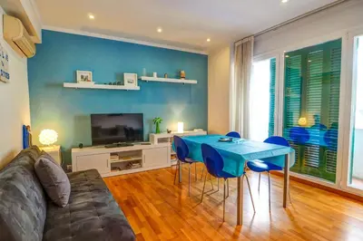a living room with a couch and a blue table at Aire Apartment by Hello Homes Sitges in Sitges