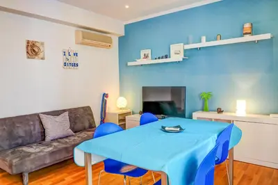 a living room with a blue table and a couch at Aire Apartment by Hello Homes Sitges in Sitges