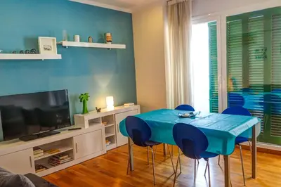 a living room with a blue table and chairs at Aire Apartment by Hello Homes Sitges in Sitges