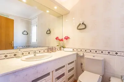 a bathroom with a sink and a toilet and a mirror at HomeHolidaysRentals Aube in Sant Cebrià de Vallalta