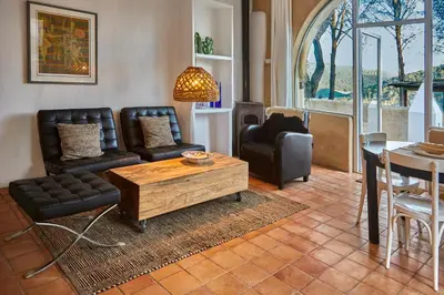 a living room with leather furniture and a table at Casa Los Arcos at Masia Nur Sitges, Adults only in Canyelles