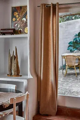a curtain in a room with a window at Casa Los Arcos at Masia Nur Sitges, Adults only in Canyelles